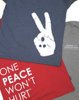 Three shirts lay, overlapping, on a white surface. The shirts show various Peace by Chocolate designs.