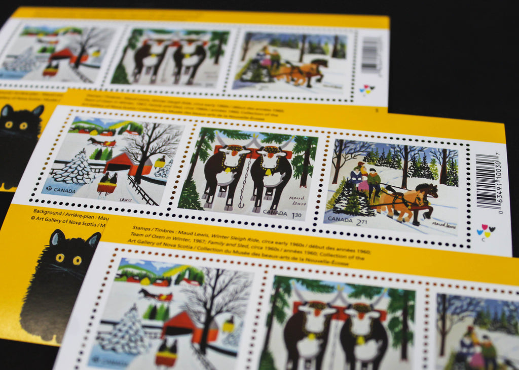 Three souvenir stamp booklets lay, overlapping, on a black surface.